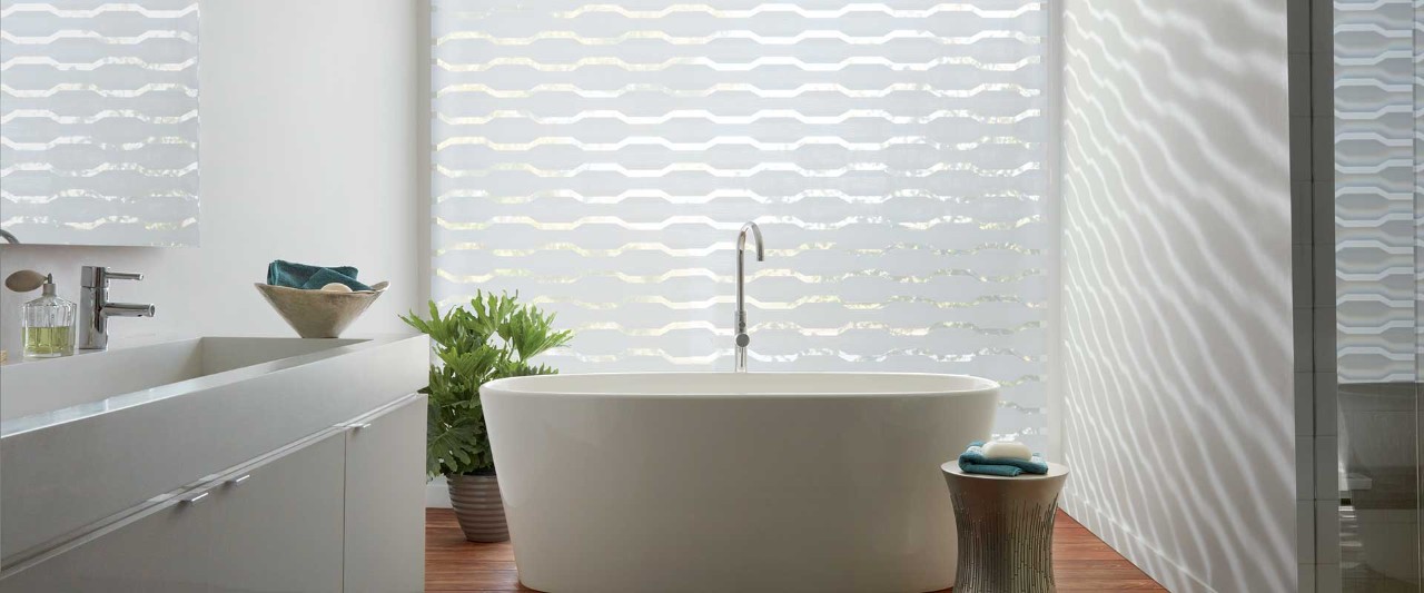Bathtub in front of white designer banded shades.